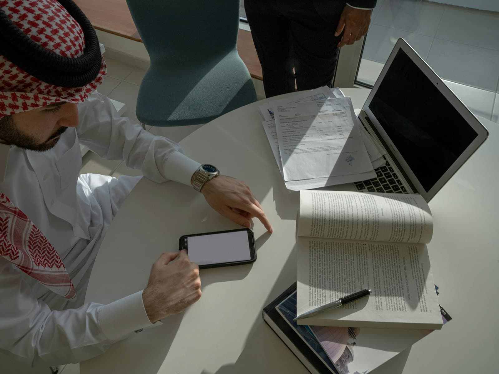 Executive working through strategy documents at a meeting table
